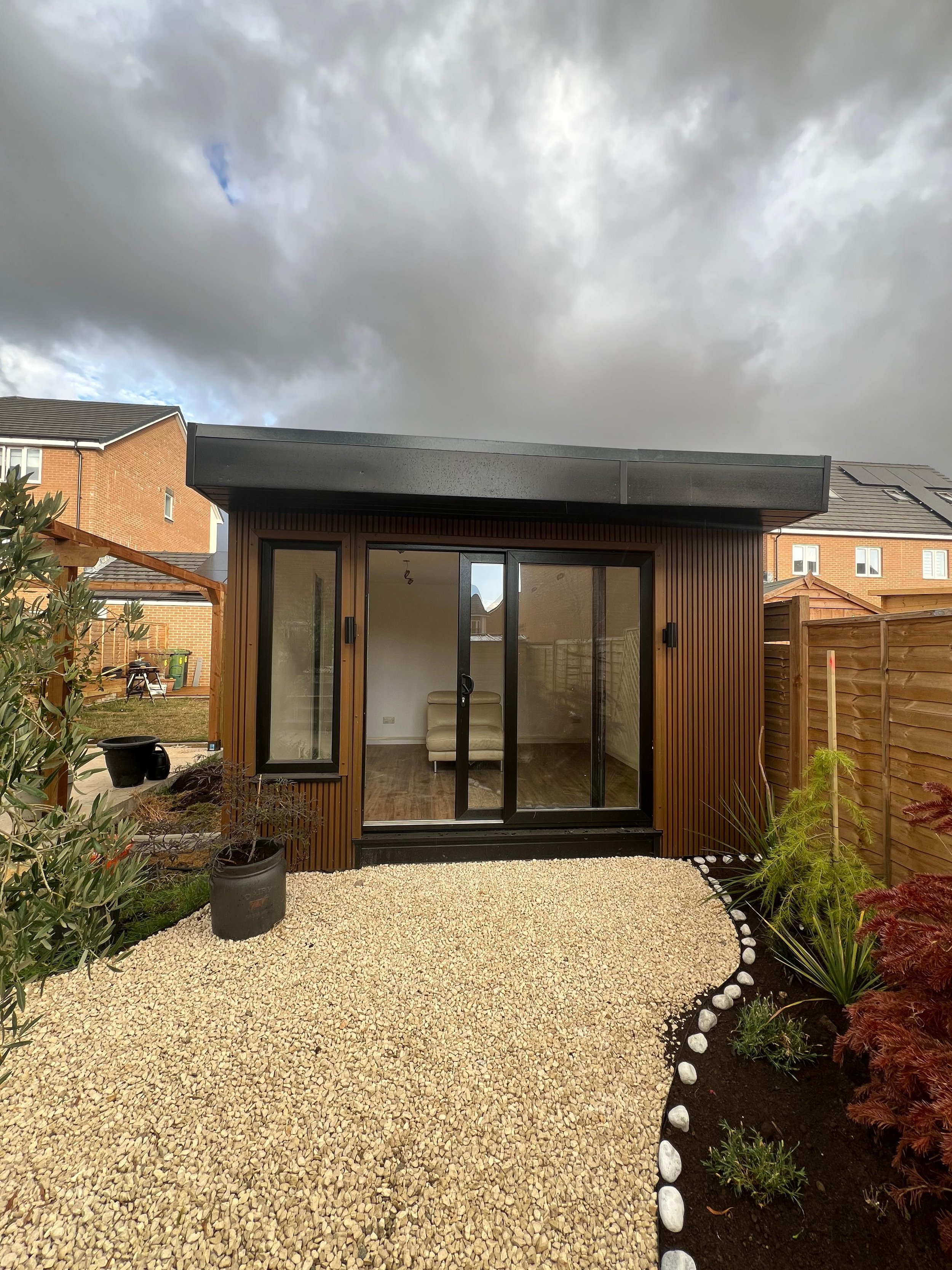 Garden room with composite cladding and gravel pathway