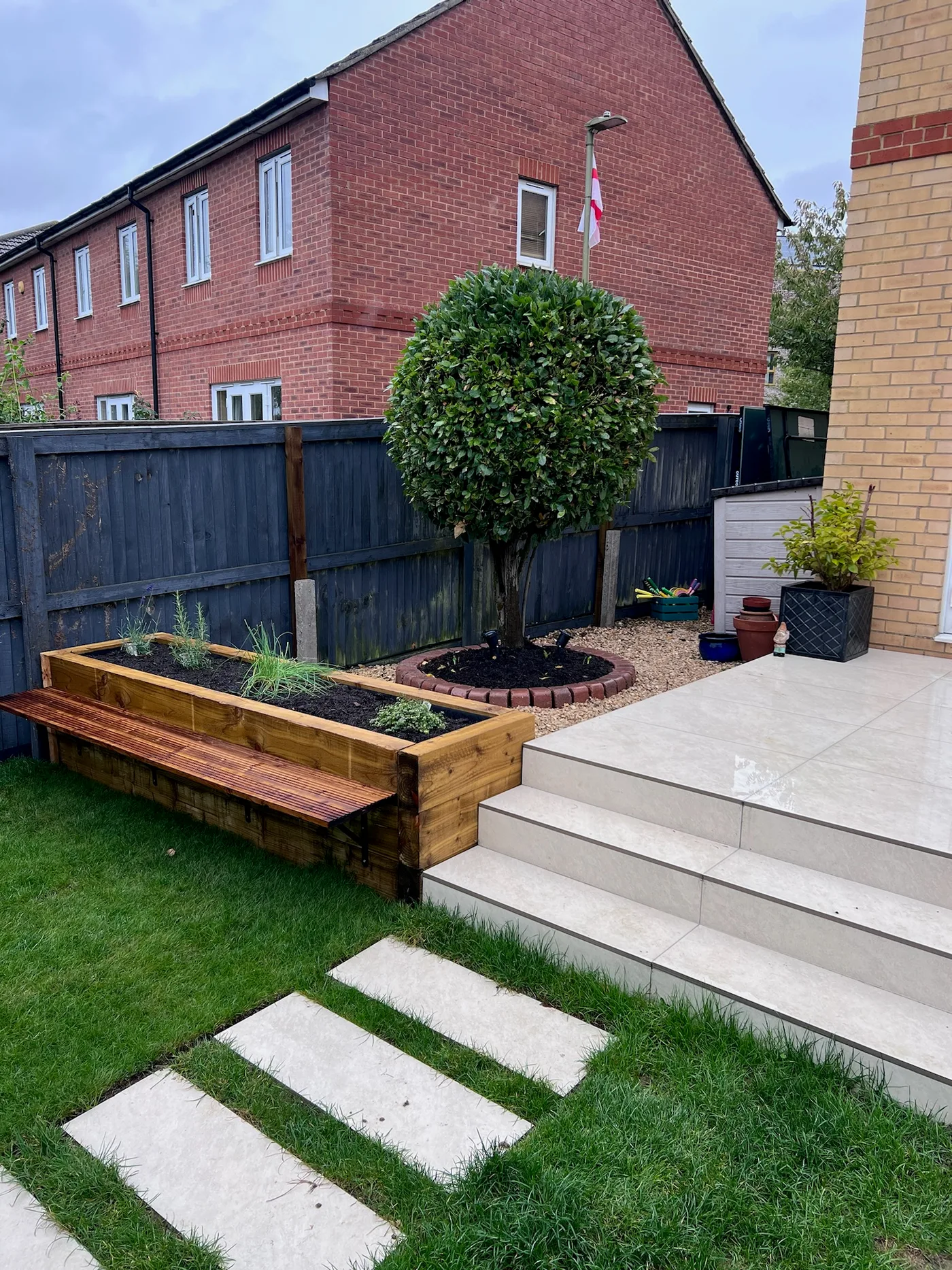Patio with garden beds and tree