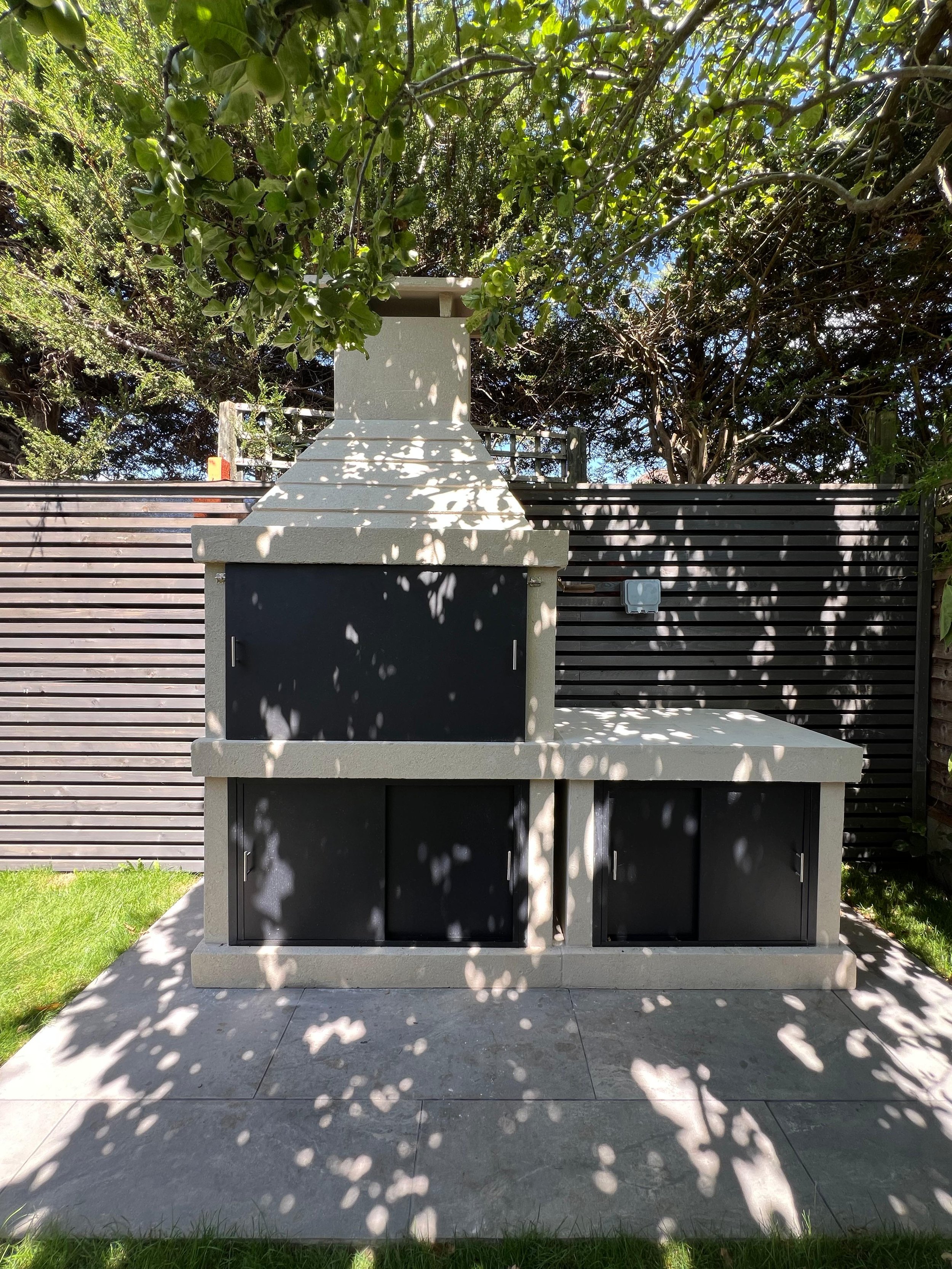 Built-in outdoor BBQ station with slatted fencing